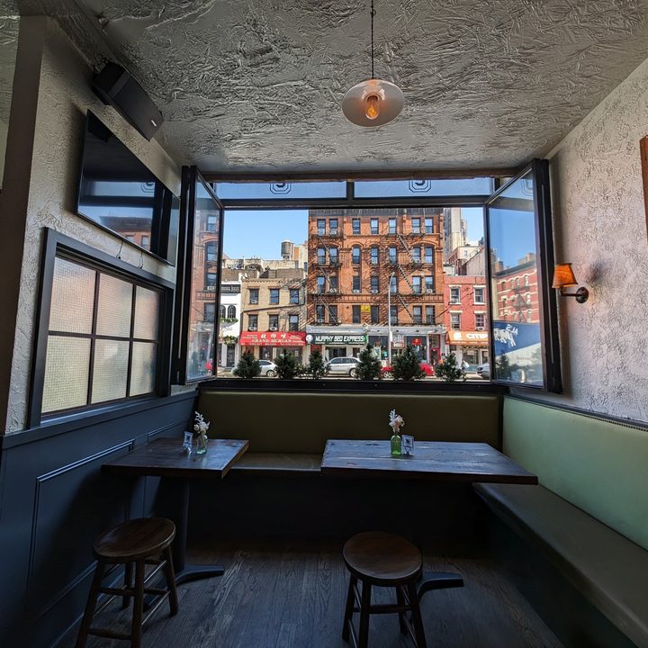 Photo of a restaurant in New York City, with a window looking at a building across the street, taken with the Google Pixel 8 Pro.