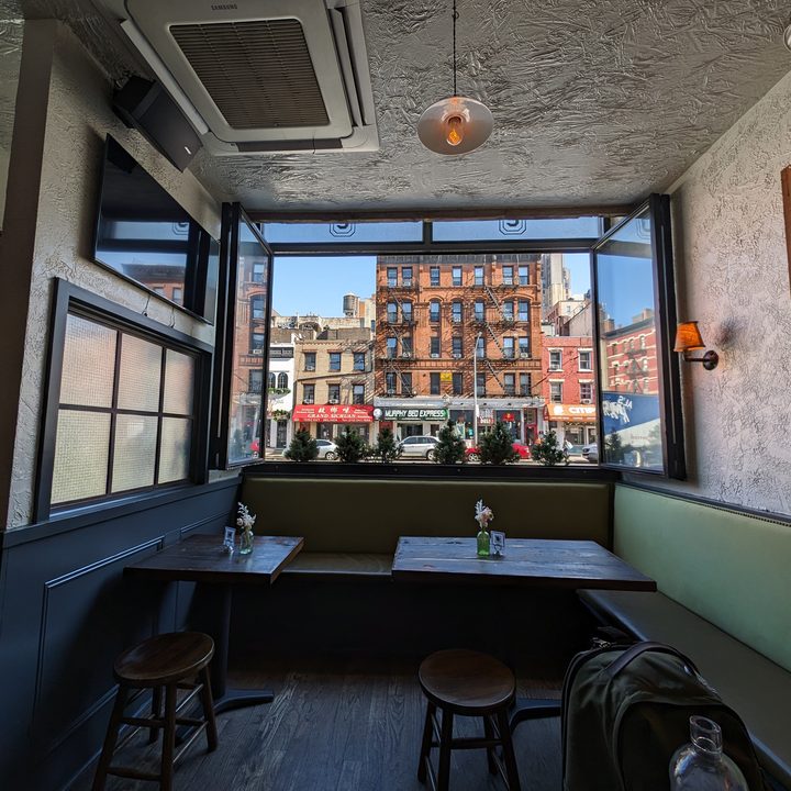 Photo of a restaurant in New York City, with a window looking at a building across the street, taken with the Google Pixel 8 Pro.