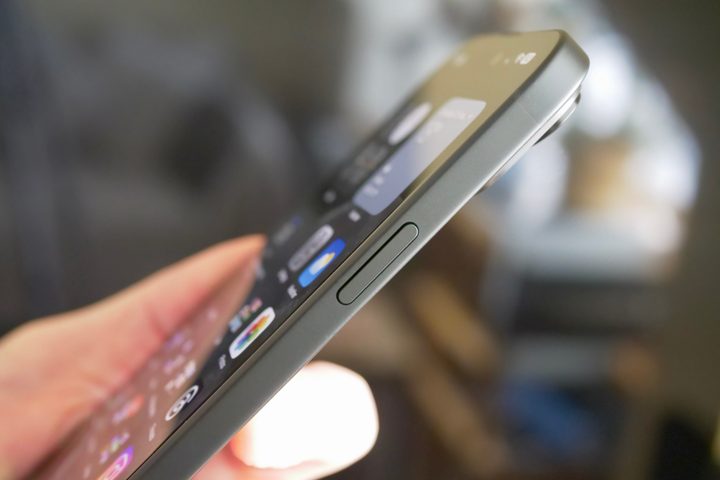 A person holding the Apple iPhone 15 Plus, showing the power key.