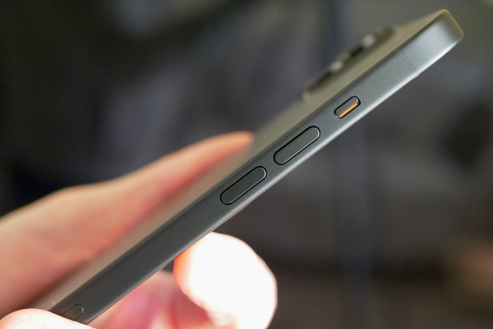 A person holding the Apple iPhone 15 Plus, showing the volume keys