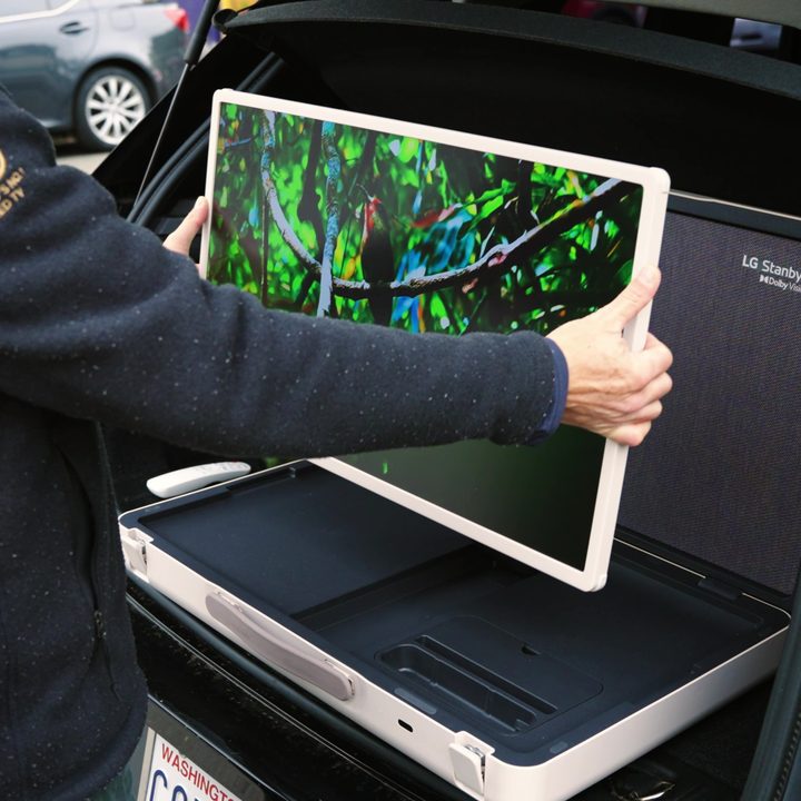 A man adjusts the 27-inch monitor of an LG StanbyMe Go.