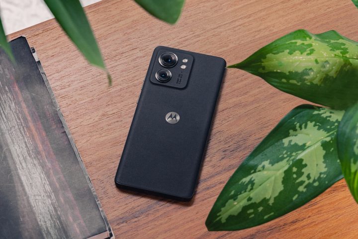 A black Motorola Edge (2023) laying face-down on a wood table.