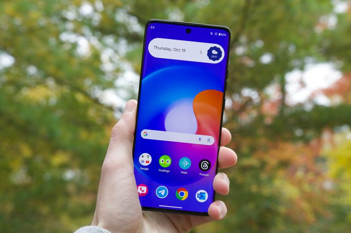 A person holding the Motorola Edge (2023) with its screen turned on.