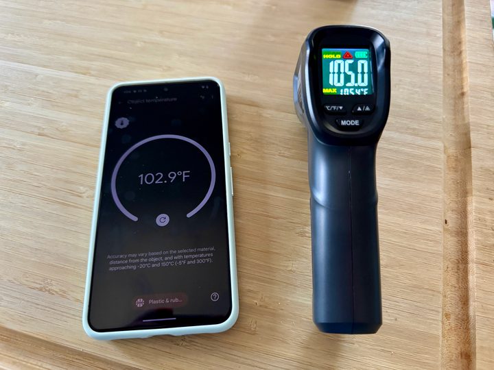 Google Pixel 8 Pro temperature reading next to an infrared temperature gun after measuring an iPhone 15 Pro in an OtterBox case that was charging on MagSafe.