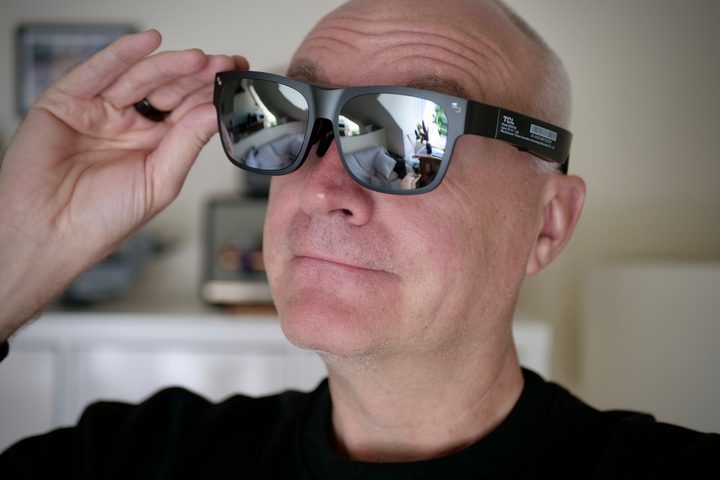 A person wearing the TCL RayNeo Nxtwear S XR glasses.