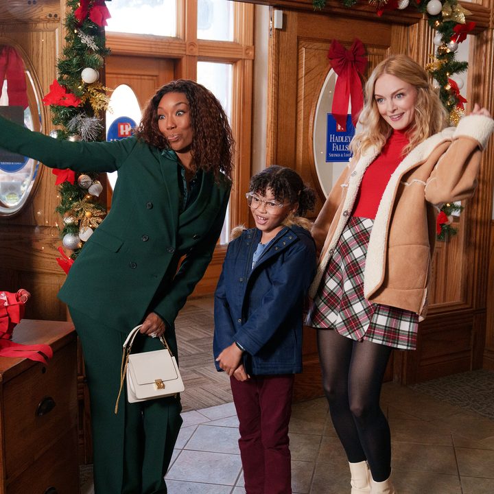 Two women stand next to a child and pose.