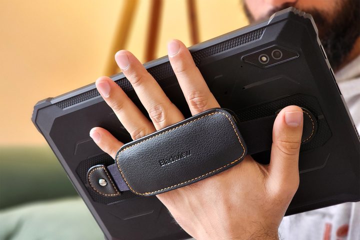 Man holds Blackview Active 8 Pro rugged Android tablet in black color with a leather strap around a man's palm.