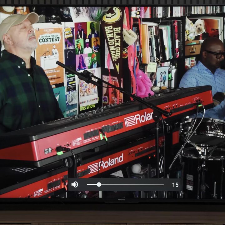 A musician plays a keyboard setup shown on a Hisense UX TV.