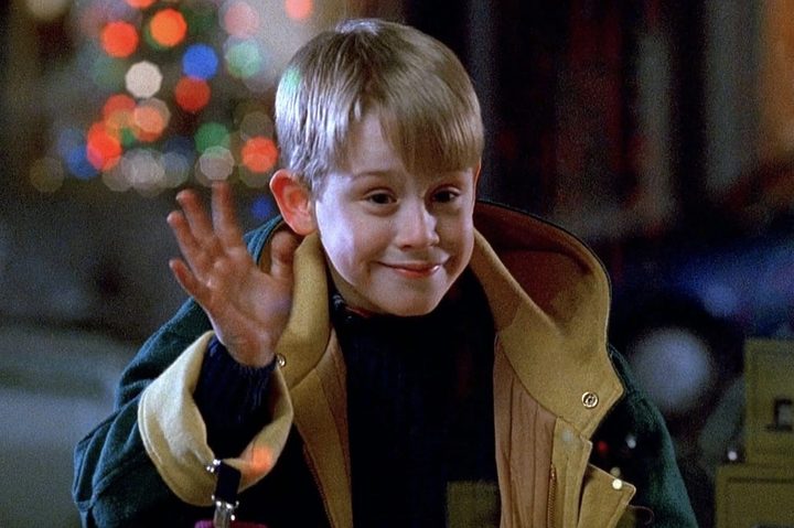 A young boy waves hi.