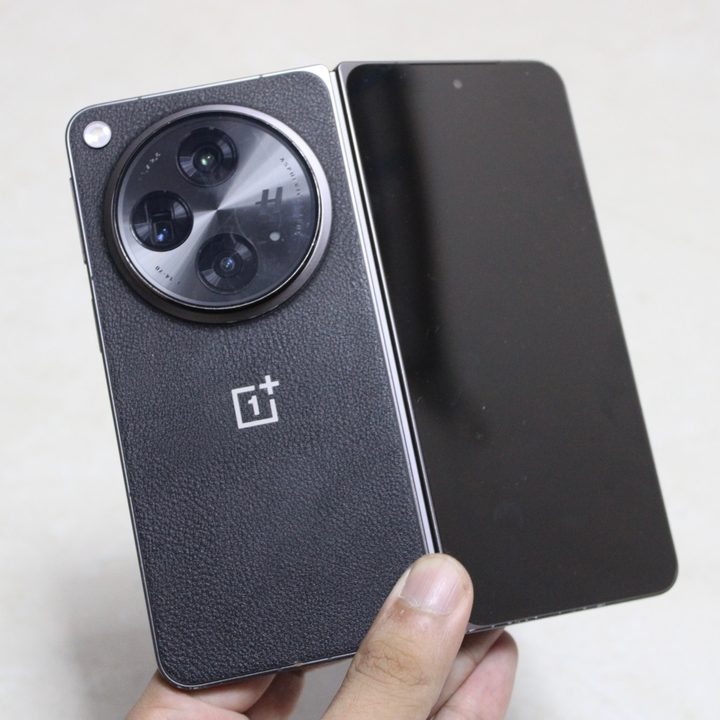 OnePlus Open from the back, in hand and less than half folded.