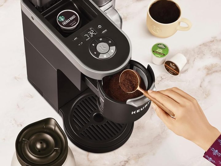 Pouring coffee grounds into the Keurig K-Duo Plus coffee maker.