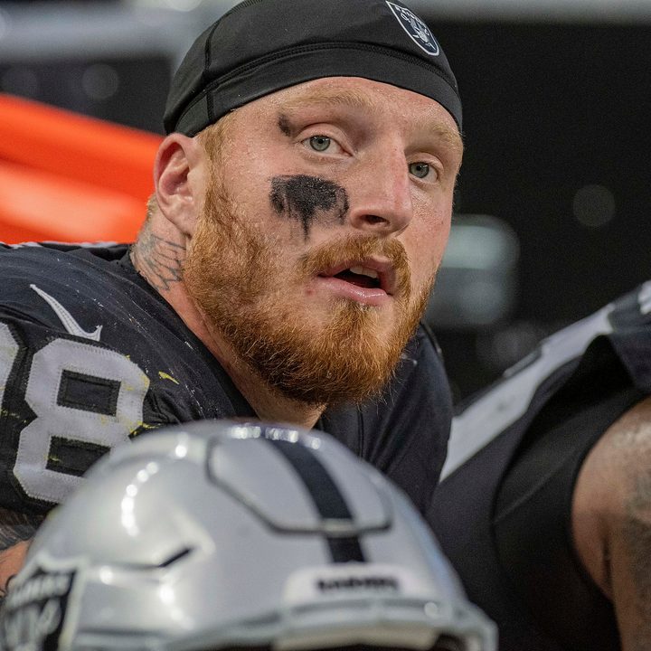 Maxx Crosby sits on the sideline and stares.