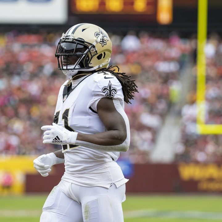 Alvin Kamara jogs on a football field.