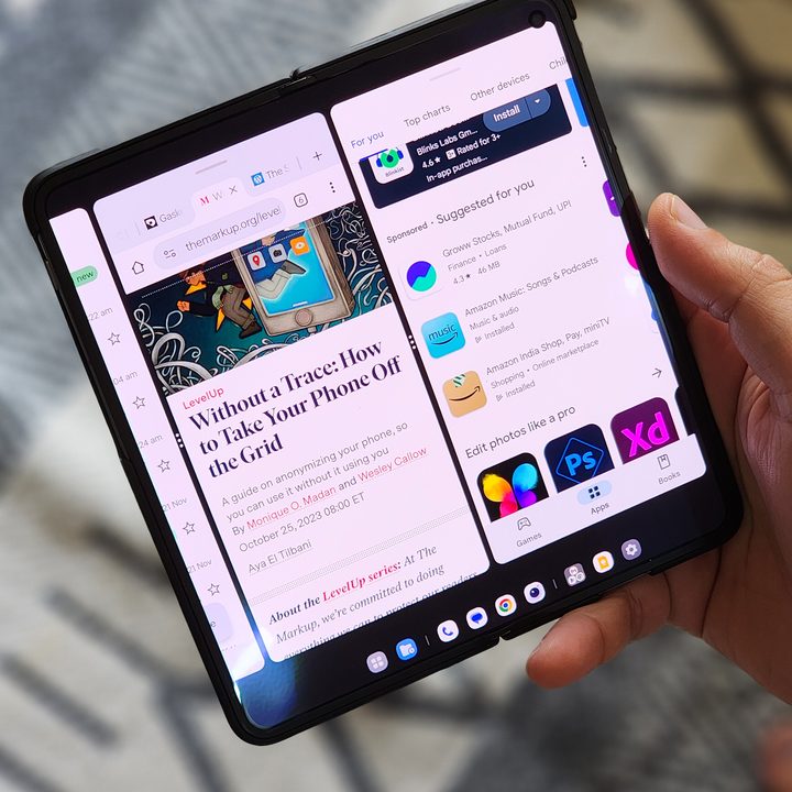 Three apps running side by side using multitasking features on a OnePlus Open held in hand.