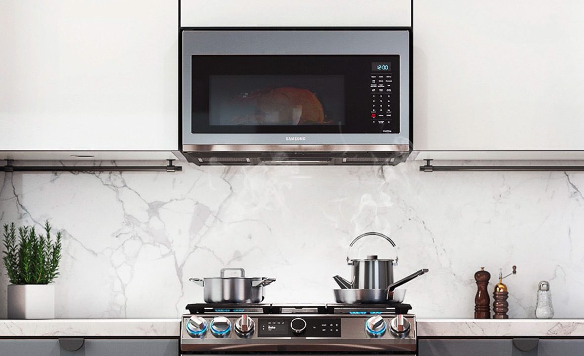 The Samsung 1.7 cu ft. Smart Over-the-Range Microwave mounted in a kitchen.