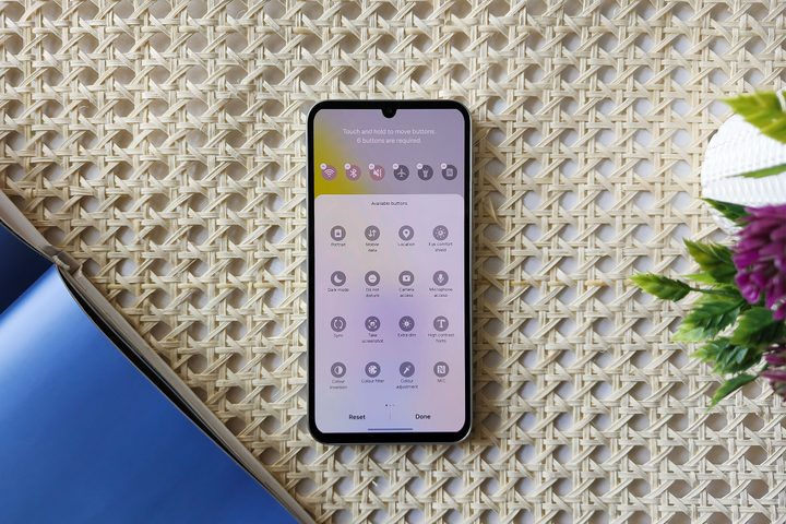 Samsung One UI 6 Quick Settings editing option on Galaxy A34 kept on a table with retan surface.