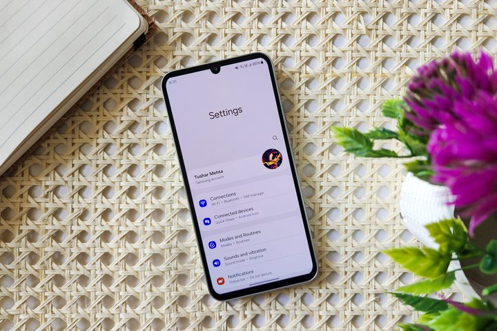 Samsung One UI 6 improved Settings app on Galaxy A34 kept on a retan surface table.