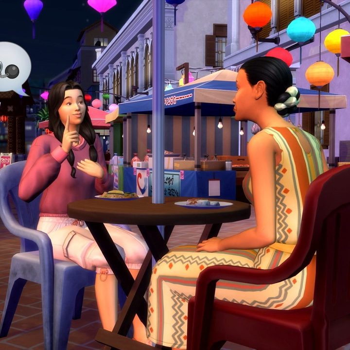 Two Sims sit at an outdoor cafe table at night, chatting.