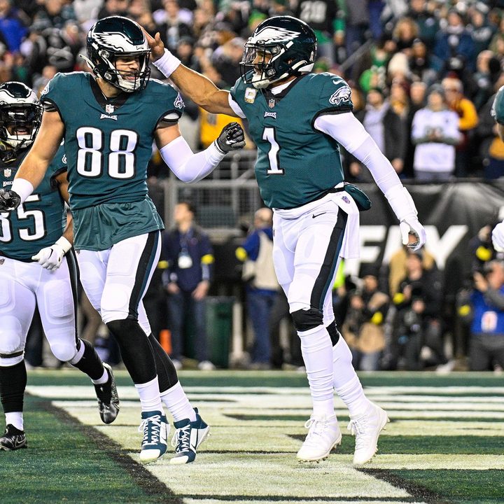 Three Eagles players celebrate in the end zone.