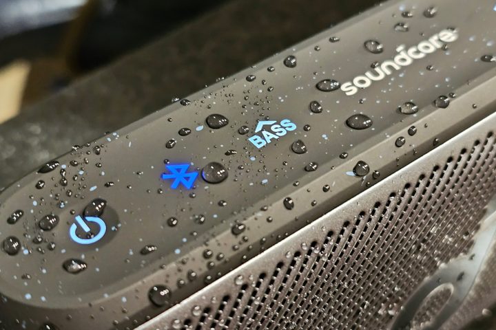 Soundcore Motion 300, close-up of top controls with water droplets.