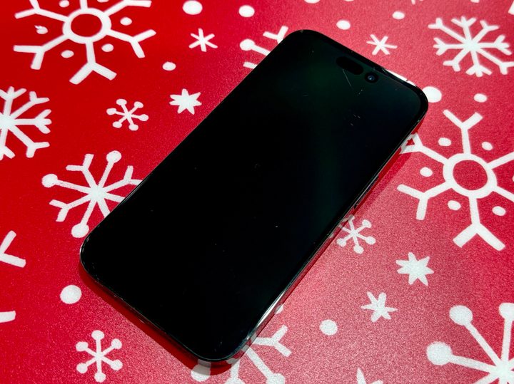 A picture of an iPhone 14 Pro, showing various scratches on its screen.