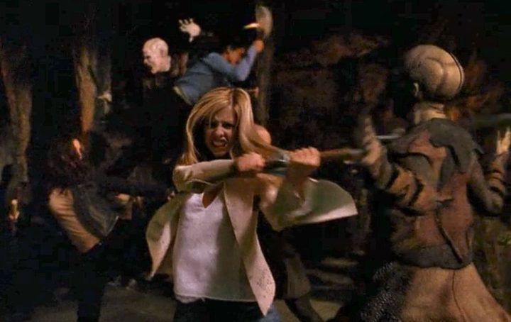Buffy swings her scythe through a vampire in the final battle of Buffy the Vampire Slayer