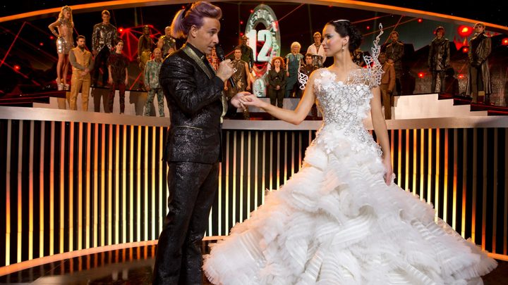 A man holds a woman's hand in The Hunger Games Catching Fire.