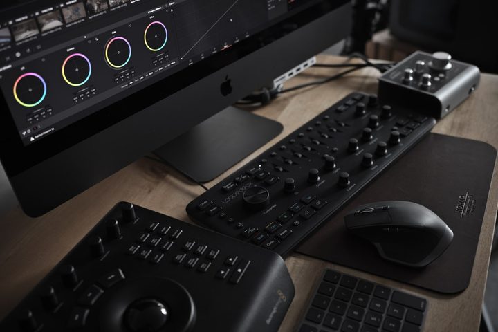 An iMac Pro on a desk with a range of accessories, including a Loupedeck board, a mouse, a keyboard, and other audio equipment.