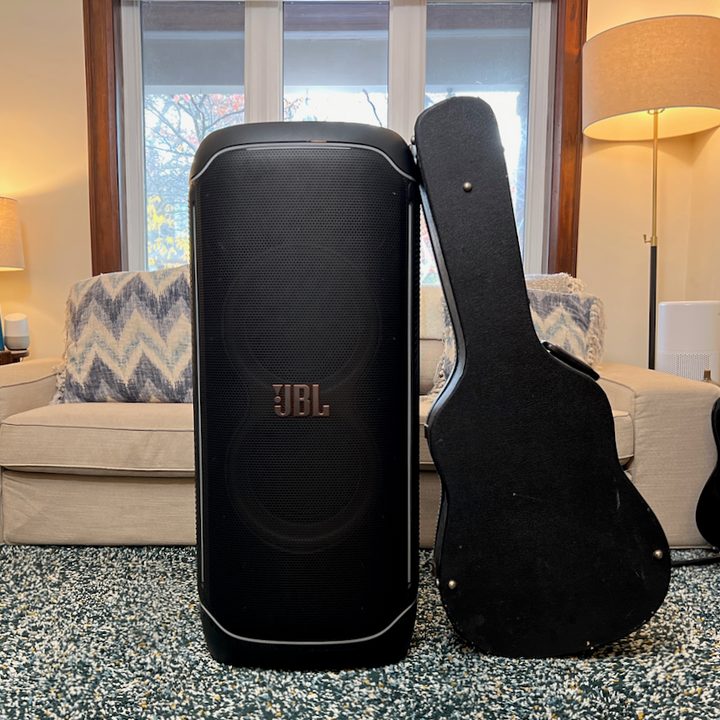 The JBL PartyBox Ultimate standing next to a guitar case for perspective.