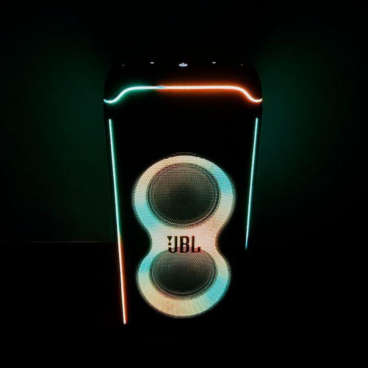 The JBL PartyBox Ultimate speaker glowing in the dark.