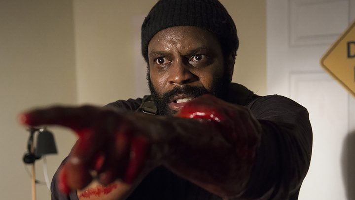 Tyreese holding his blood soaked hands out in front of him, looking distressed in a scene from The Walking Dead.