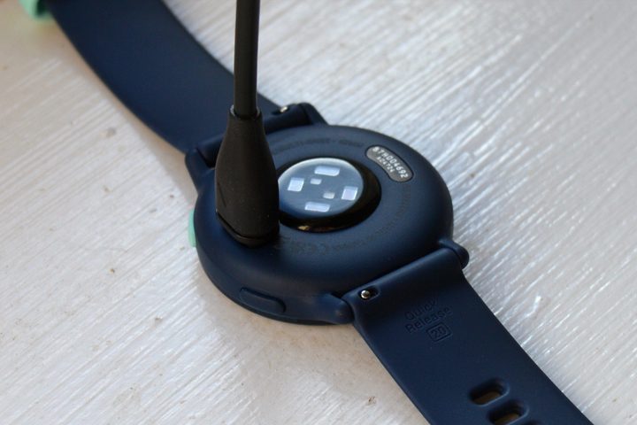 The Garmin Vivoactive 5 with the charging cable attached.