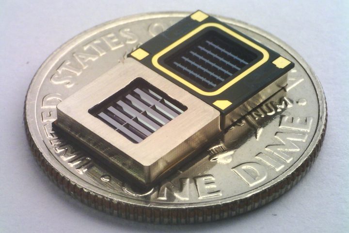 Two xMEMS Cypress drivers seen sitting on a U.S. dime coin for scale.
