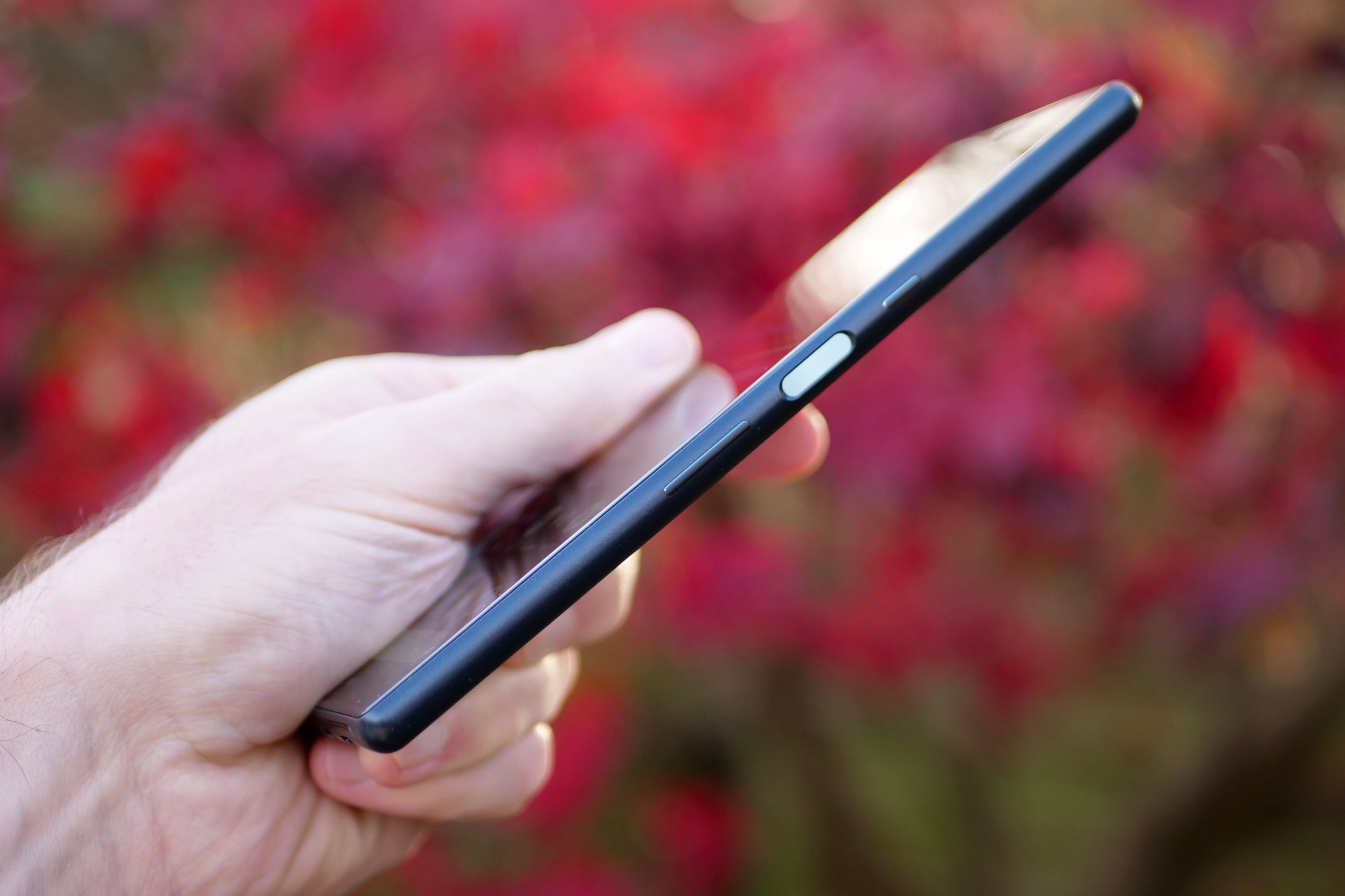 A person holding the Sony Xperia 10 Plus, showing the fingerprint sensor.
