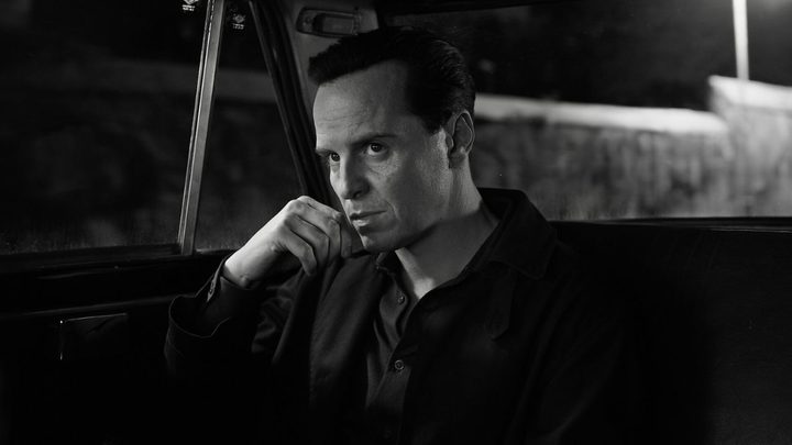 Andrew Scott as Tom Ripley looking intently off camera from the backseat of a car in Netflix's Ripley.