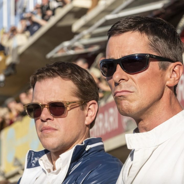 Two men stand next to each other and stare.