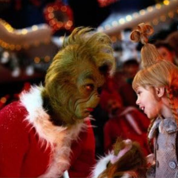 The Grinch and Cindy Lou Who talk while standing next to each other.