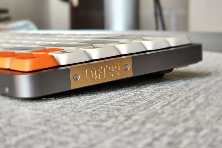 Lofree Flow low profile mechanical keyboard with Kailh switches and white retro styles dye-sub pbt keycaps on a desk seen from the side.