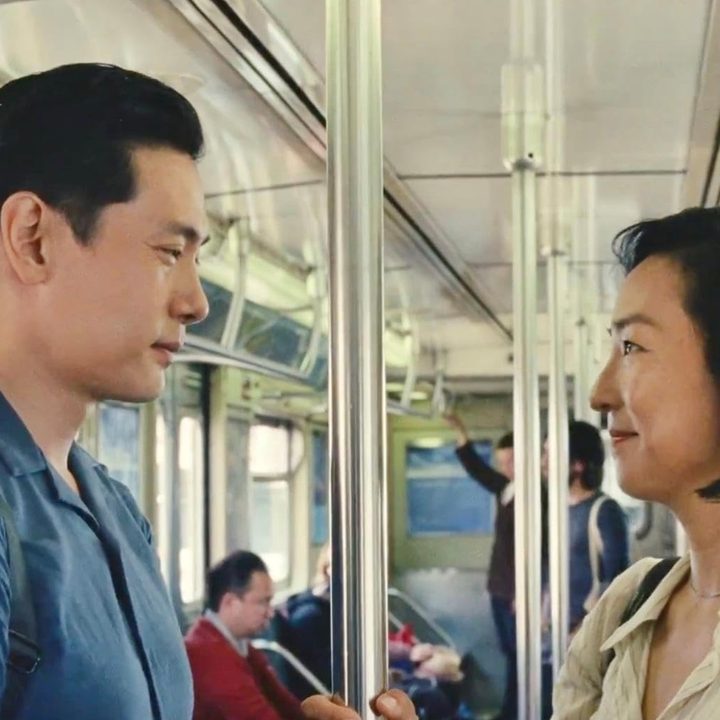 Two people stare at each other on the subway.