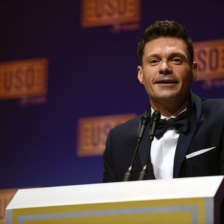 Ryan Seacrest stands at a podium and speaks.