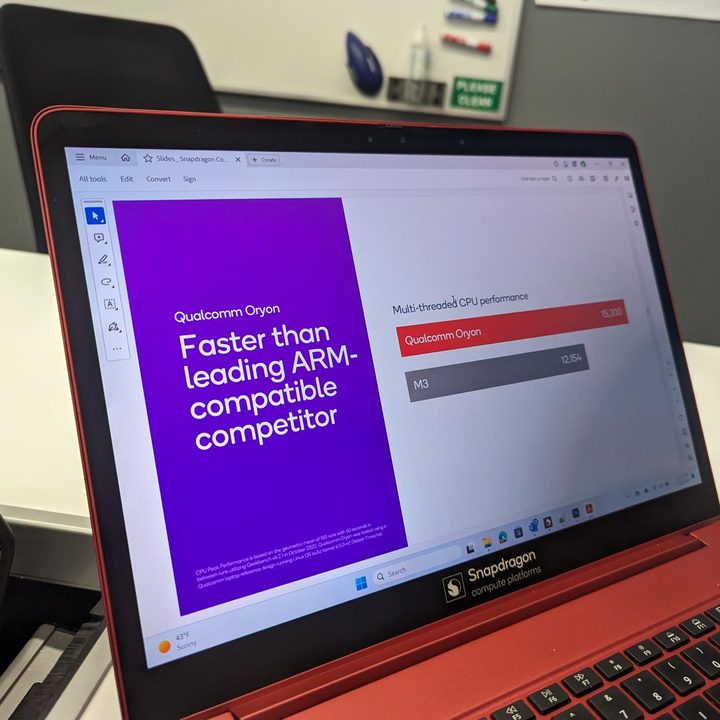 A Qualcomm demo laptop with a slide showing performance comparisons.