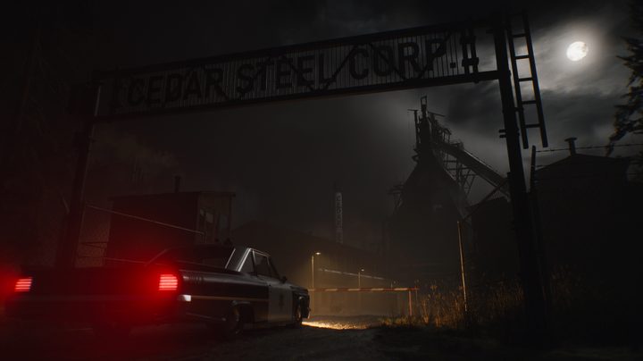 A cop car parked outside a steel mill.