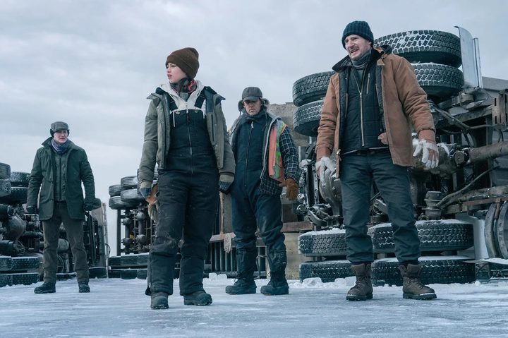Truck drivers stand next to a broken down truck in The Ice Road.