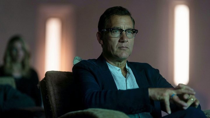 Andy sitting in a chair looking stoic in a scene from A Murder at the End of the World.
