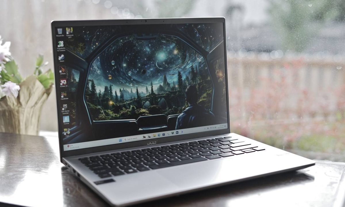 The Acer Swift Go 14 on a table in front of a window.
