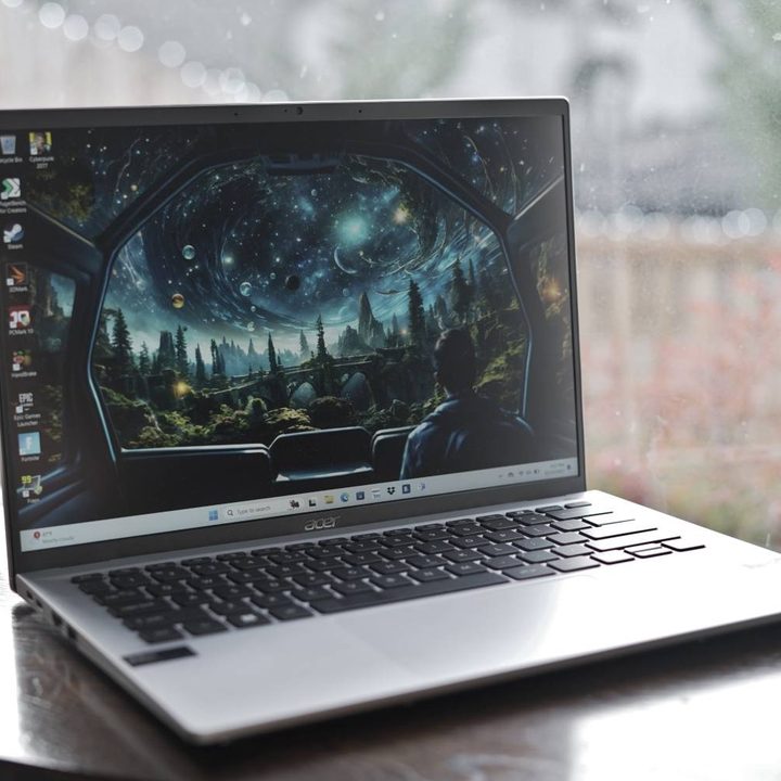 The Acer Swift Go 14 on a table in front of a window.