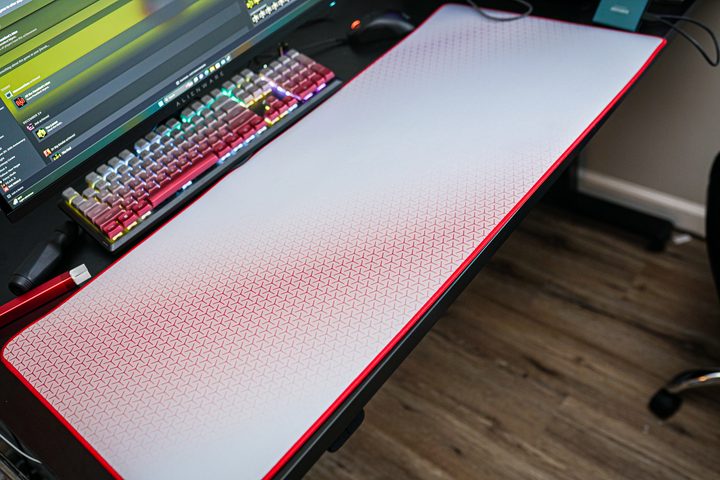 A Corsair desk mat sitting on a desk.