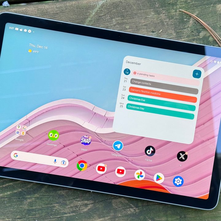 The Google Pixel Tablet sitting outside with its screen on.