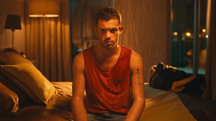 A man sits on a bed in I Am Jonas.