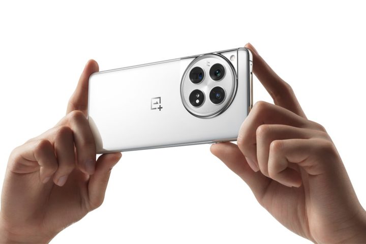 A photo of someone holding the white/silver OnePlus 12.